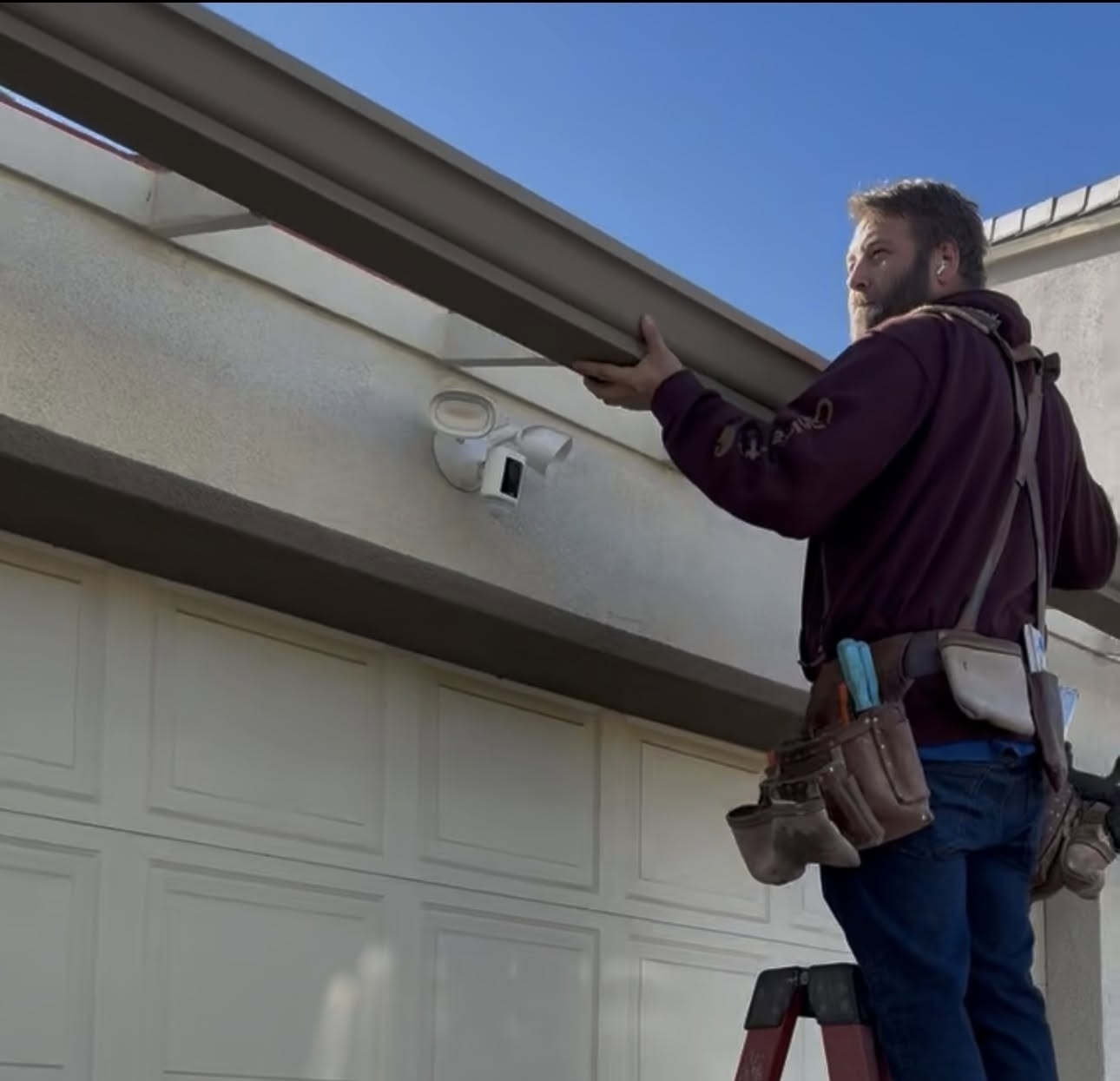 John rehanging gutters on a house